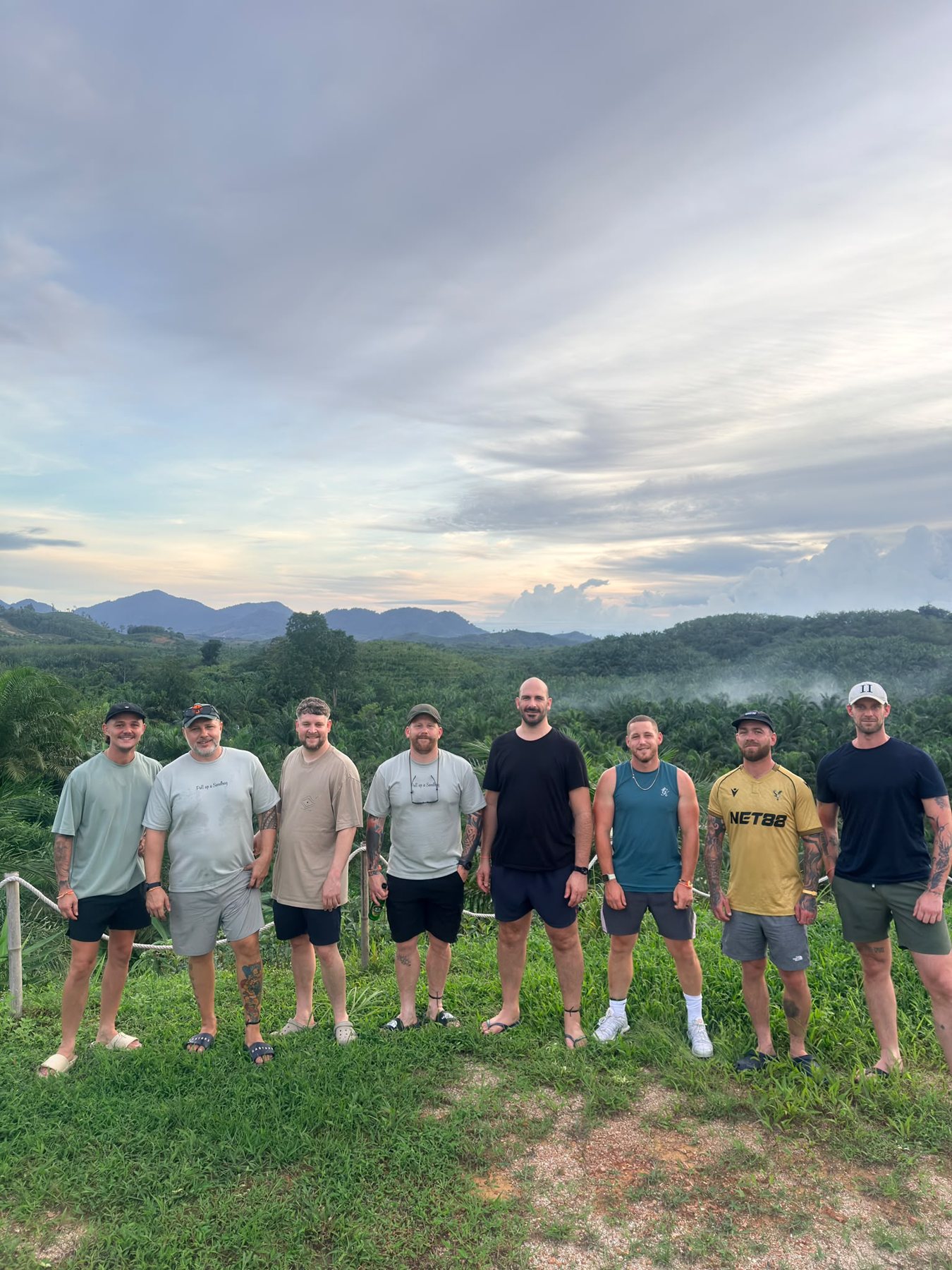 The full June 2026 cohort standing together on a hillside overlooking Phuket at dusk