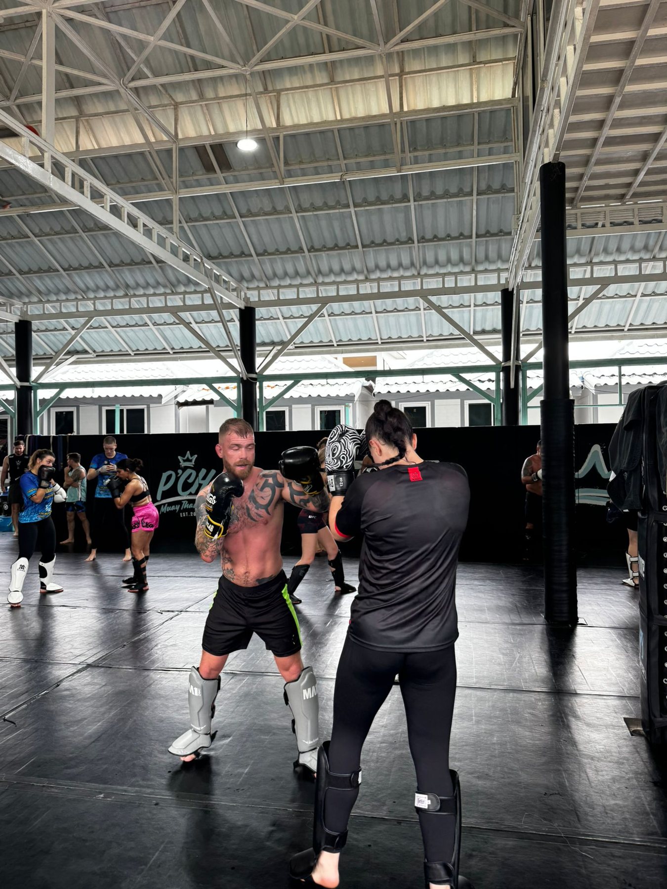 A veteran training Muay Thai with a pad coach during a Pull Up a Sandbag retreat session